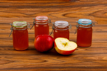 Apfelmarmelade in Gläsern und frischen Äpfeln
