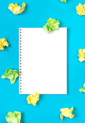 Bright creativity concept of the idea, white notepad and colorful crumpled papers, flat lay