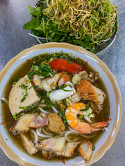 Vertical photo of delicious Vietnamese seafood noodles soup