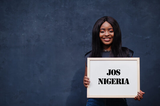 African woman hold white board with Jos Nigeria inscription. Most populous city in Africa concept.