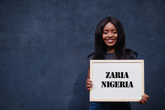 African woman hold white board with Zaria Nigeria inscription. Most populous city in Africa concept.
