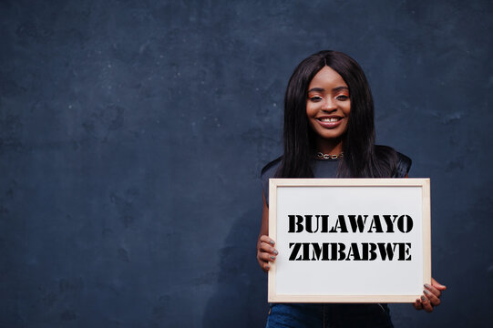 African woman hold white board with Bulawayo Zimbabwe inscription. Most populous city in Africa concept.