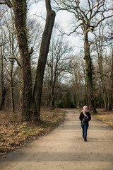 A girl walking through a park in Autumn.