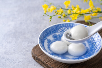 Close up of tangyuan in a bowl on gray table, food for Winter Solstice.