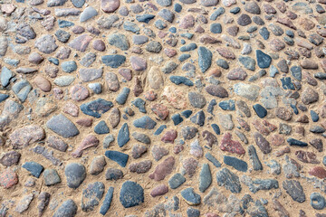 The surface of the cobblestone pavement, lined with round smooth stones.