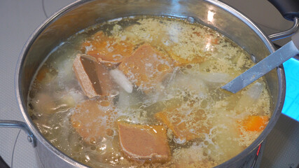 煮込んだスープにシチューのルウを入れる様子