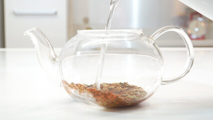 ガラスのティーポットに熱湯を注ぐ様子　ルイボスティー