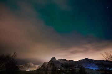 Aurora borealis Green northern lights above mountains