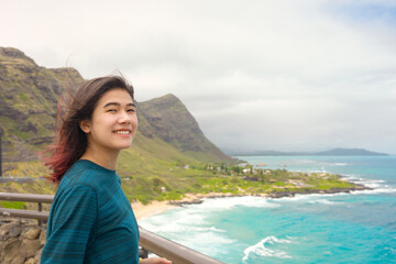 Fototapeta na wymiar Teen girl standing above tropical Hawaiian ocean scenery