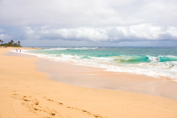 Fototapeta na wymiar Blue green waters of the Pacific Ocean crashing onto beach