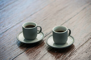 Two modern espresso in grey cups on a wooden table