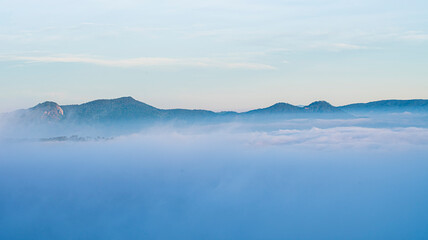 Many houses in in the mist in the morning. Early morning fog and mist burns off over large houses nestled in green rolling hills