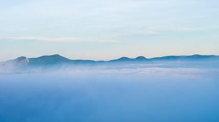 Many houses in in the mist in the morning. Early morning fog and mist burns off over large houses nestled in green rolling hills