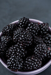 Many blackberries in a plate on a black background Stacked image Still life photography