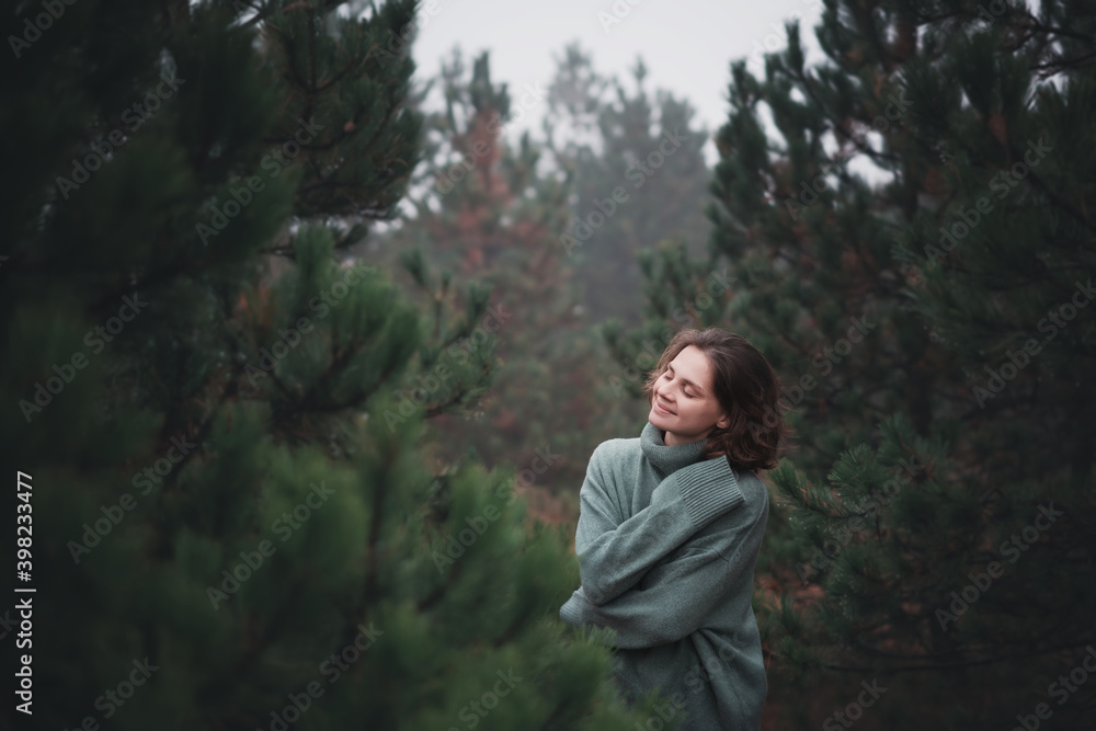 Wall mural young beautiful happy woman walking in fir forest enjoying nature meditating outdoors