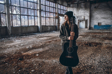 Young Girl Playing Guitar in an Abandoned Hall