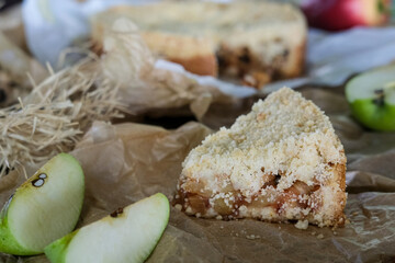 Sliced delicious apple pie with ingredients on wooden background