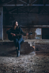 Young Beautiful Girl with Guitar in Dark Empty Factory Hall