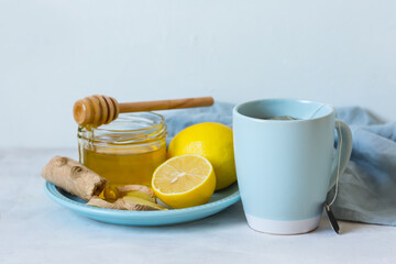  Folk remedies for the treatment of colds. Honey, lemon, ginger and Tea with lemon on a light table. Organic cold medicine. Natural remedies for colds