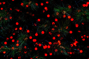 Red background Abstract Bokeh Christmas. Christmas twinkled bright Falling stars on the fir tree. Winter Card or invitation. High quality photo