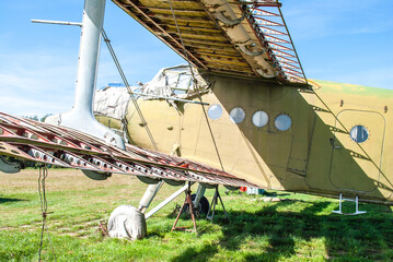 Small old plane standing in summer green field