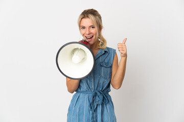 Young Russian woman isolated on white background shouting through a megaphone to announce something...