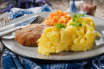 Minced meat cutlet served with mashed potatoes and carrot salad.
