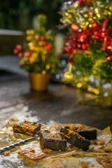 Christmas cakes and cookies on wooden table by festive decorated fir tree