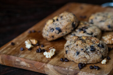 Chocolate chip cookies with walnuts on wooden chopping board background