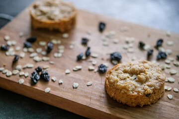 Oatmeal cookies with raisins on rustic wooden chopping board background