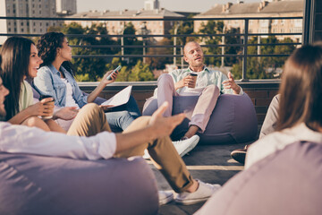 Nice stylish cheery partners sitting in bag chairs discussing corporate strategy plan unity...