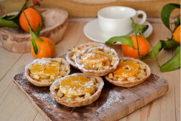 Naklejka na ściany i meble Mini fruit tarts with caramelized apple and tangerine. Homemade baking. Rustic style.