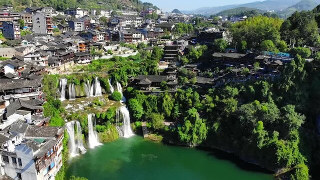 Aerial view of beautiful Furong waterfall in famous Ancient Town. Amazing aerial view of asian old town with waterfalls. Furong, Xiangxi Hunan, China. High quality royalty free stock footage.