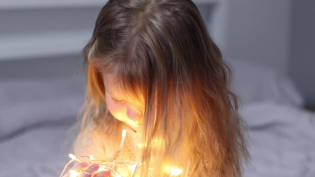 pretty little girl playing with christmas garland. new year, childhood, daughter. Full HD footage.