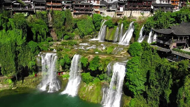 Aerial view of beautiful Furong waterfall in famous Ancient Town. Amazing aerial view of asian old town with waterfalls. Furong, Xiangxi Hunan, China. High quality royalty free stock footage.