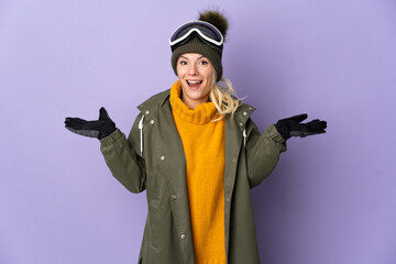 Skier Russian girl with snowboarding glasses isolated on purple background with shocked facial expression