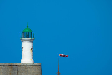 Lighthouse and weather vane against clear sky, Place for Text. 
Port de L′Île Rousse, Corsica