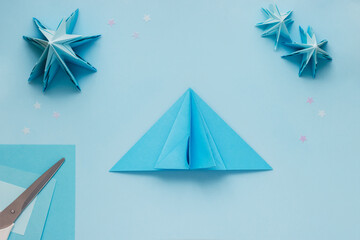 Simple origami 3D Christmas tree made from blue paper. Step by step instruction, step 12. Repeat...