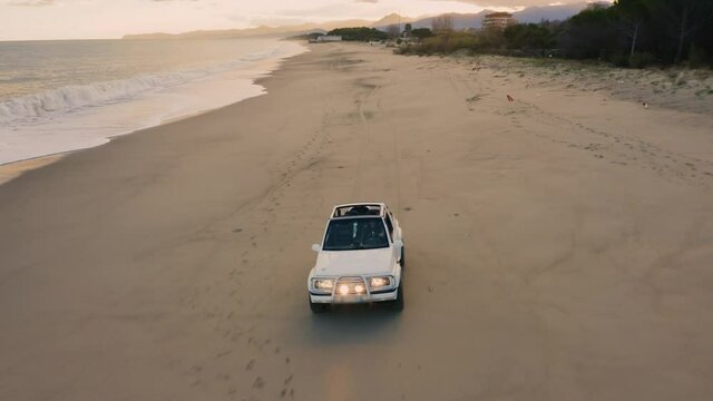 Macchina fuoristrada bianco va sulla spiaggia