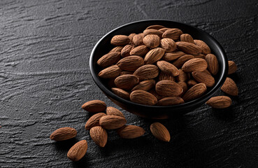 Almond nuts on black background, top view