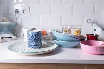 Dirty mugs and dishes on a white domestic kitchen