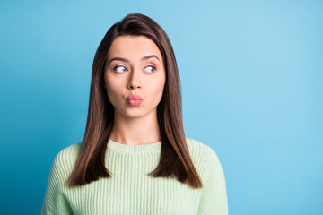 Obraz premium Photo of pretty young girl send air kiss look empty space wear green sweater isolated blue color background