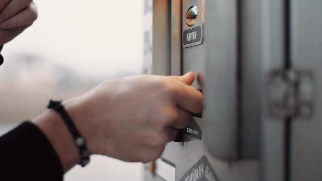 Man on manual carwash uses water isolated bill acceptor and holds a button to start a water supply.