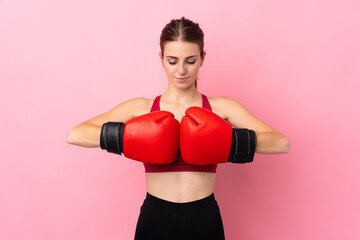 Young sport woman over isolated pink background with boxing gloves