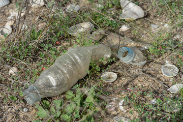 Garbage spilled in a natural setting. Empty dirty plastic bottles. Environmental pollution. Ecological problem.