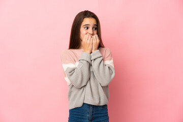 Little girl isolated on pink background nervous and scared putting hands to mouth