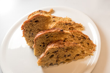 Milan panettone, cake slices made with wholemeal flour, in white plate isolated on the white