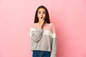 Little girl isolated on pink background surprised and shocked while looking right