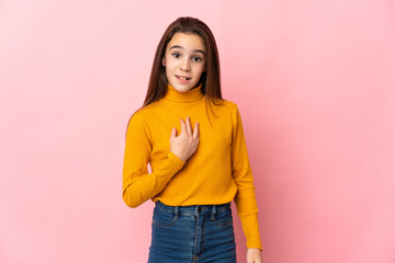 Little girl isolated on pink background pointing to oneself