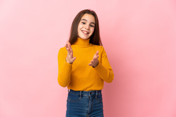 Little girl isolated on pink background applauding after presentation in a conference